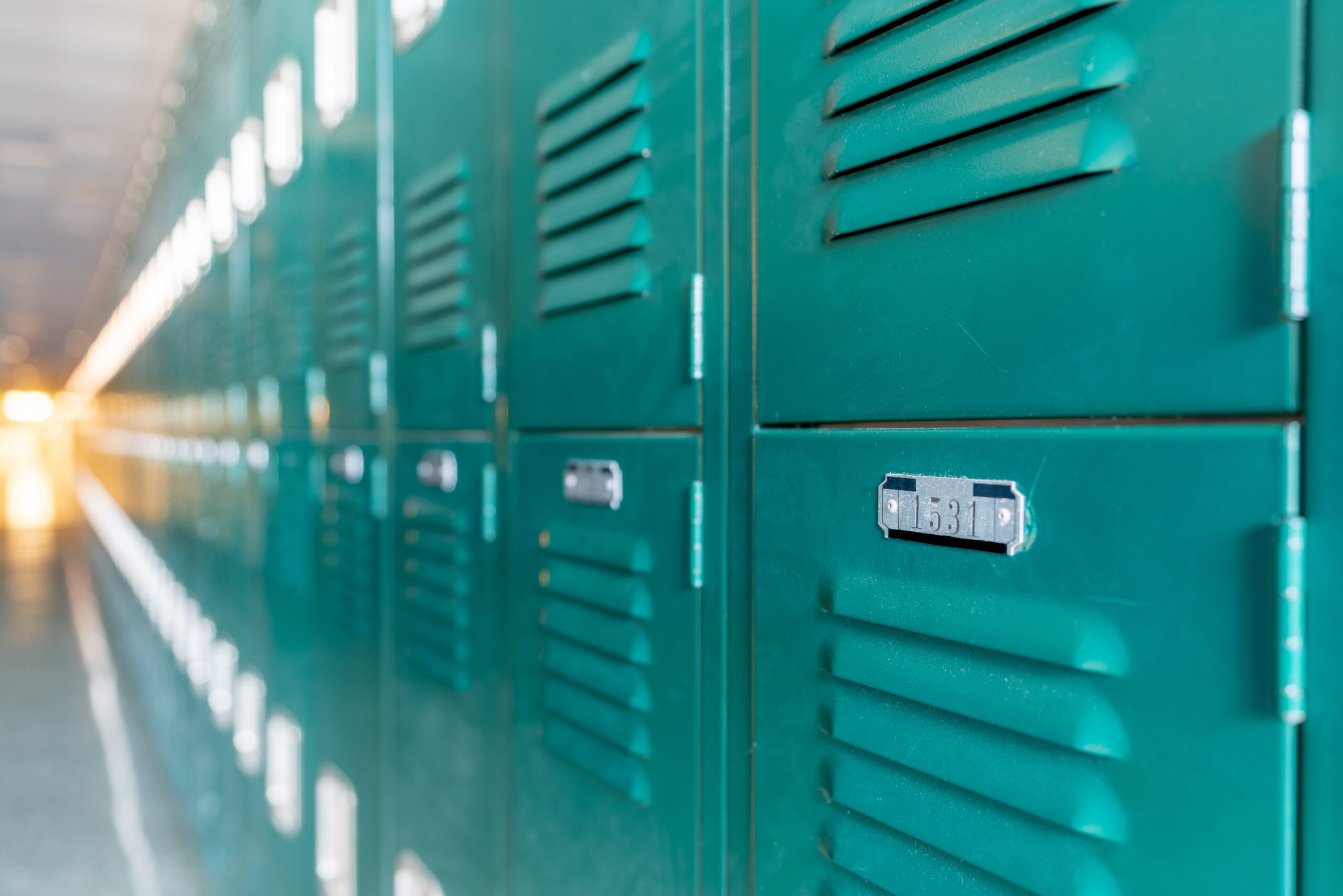 Green,Metal,Lockers,Along,A,Nondescript,Hallway,In,A,Typical